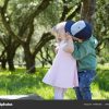 Schöne Kinder Küssen Sich Im Park. Liebeskonzept verwandt mit Kinder Bilder Junge