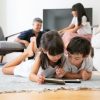 Nette Kleine Kinder, Die Auf Boden Im Wohnzimmer Liegen Und Digitale über Kinder Foto App